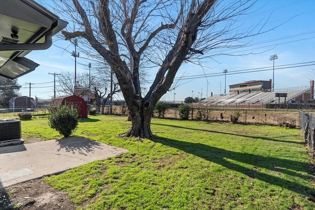 view of yard featuring central air condition unit, a shed, a trampoline, and a patio