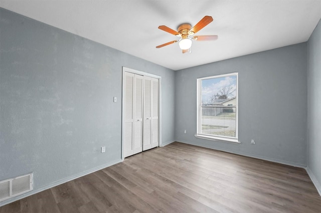 unfurnished bedroom with light hardwood / wood-style flooring, a closet, and ceiling fan