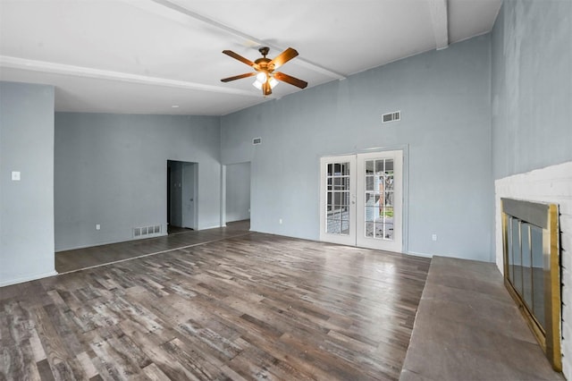 unfurnished living room with a towering ceiling, french doors, ceiling fan, and dark hardwood / wood-style flooring