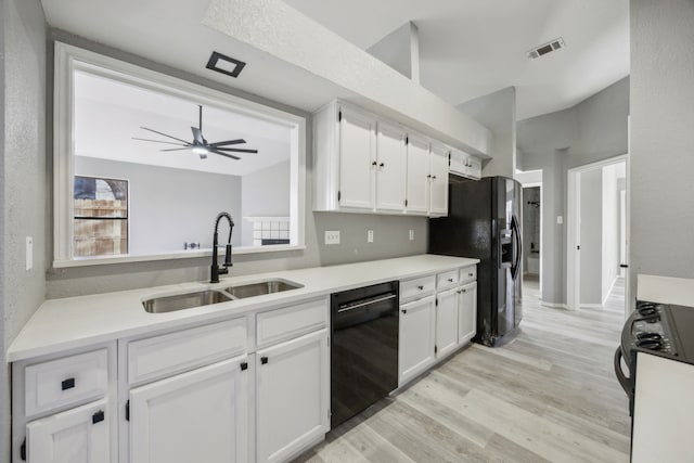 kitchen with sink, black appliances, white cabinetry, and light wood-type flooring