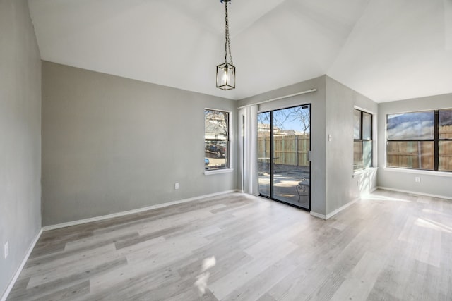 interior space with light wood-type flooring and vaulted ceiling