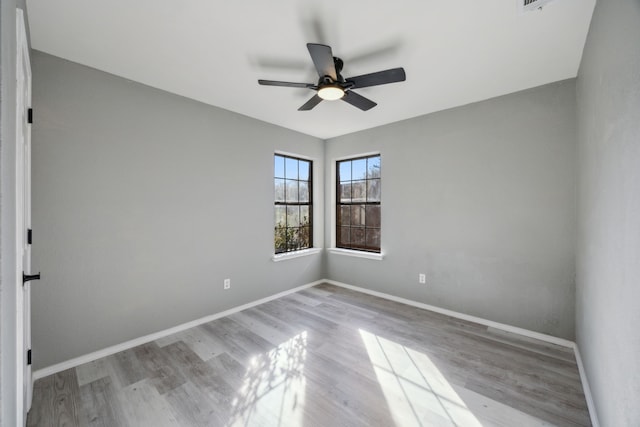 empty room with ceiling fan and light hardwood / wood-style flooring