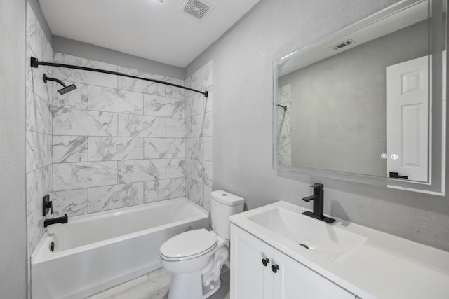 full bathroom with vanity, tiled shower / bath combo, and toilet