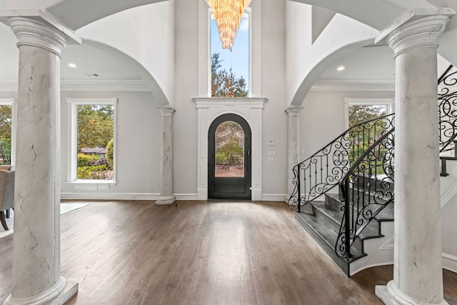 entryway with decorative columns, hardwood / wood-style flooring, and ornamental molding