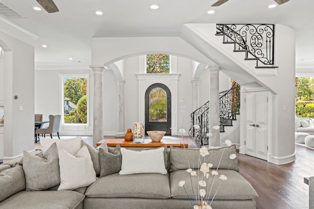 living room featuring wood-type flooring, a healthy amount of sunlight, and ornate columns