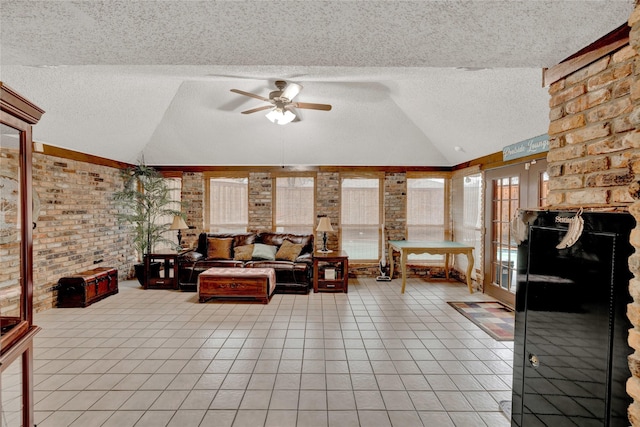 living area featuring a textured ceiling, light tile patterned flooring, and vaulted ceiling