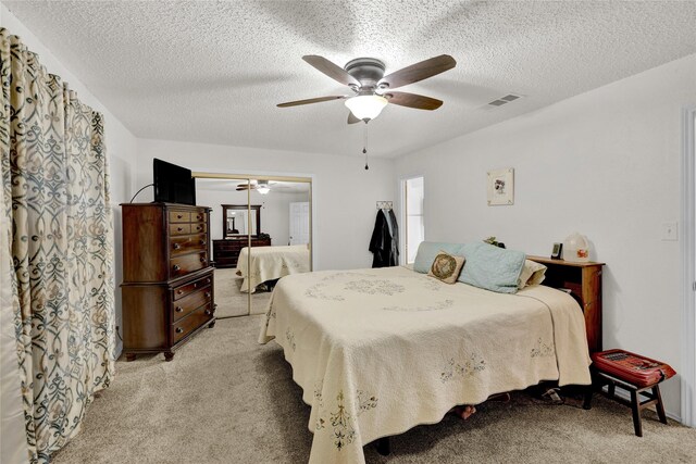 bedroom with visible vents, light carpet, a closet, and a ceiling fan