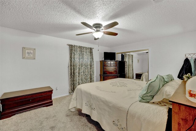 carpeted bedroom with a closet, a textured ceiling, and ceiling fan