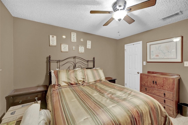 bedroom with visible vents, a textured ceiling, a ceiling fan, and carpet