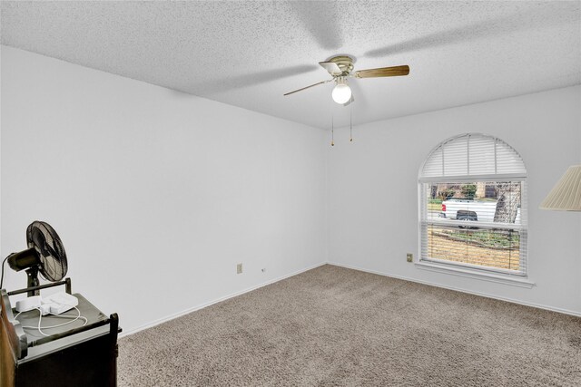 carpeted spare room with baseboards, a textured ceiling, and ceiling fan