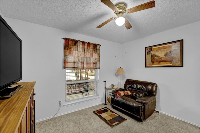 living area featuring a ceiling fan, carpet, baseboards, and a textured ceiling