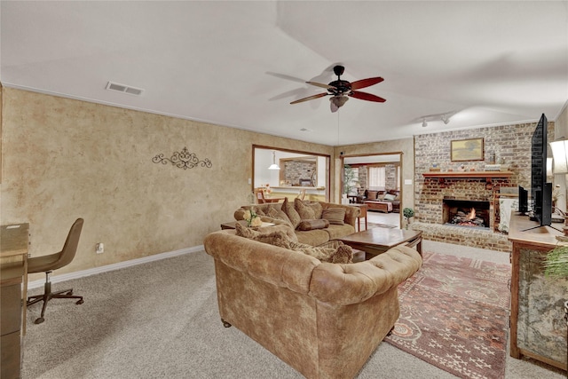 carpeted living room with visible vents, baseboards, a ceiling fan, and a fireplace