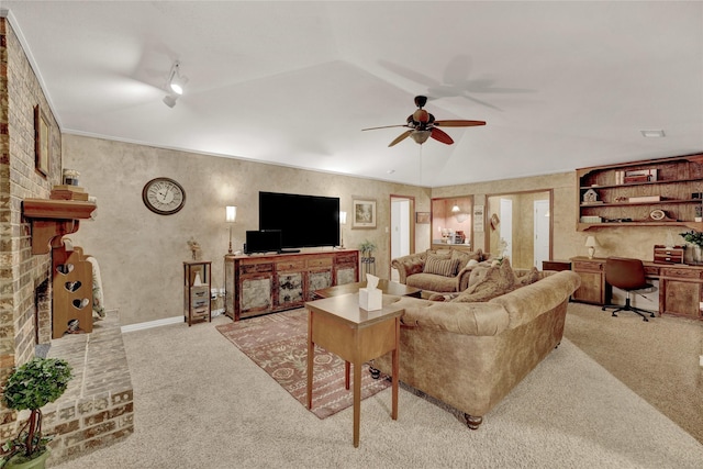 living area with a ceiling fan, crown molding, a fireplace, and light colored carpet