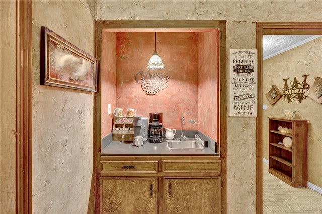 kitchen featuring brown cabinetry, pendant lighting, and a sink