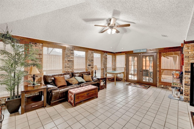 living area with vaulted ceiling, light tile patterned floors, french doors, and a textured ceiling