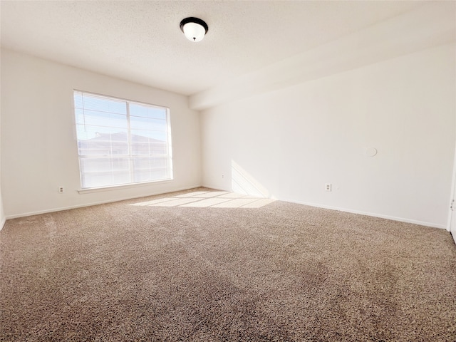 empty room with light carpet and a textured ceiling