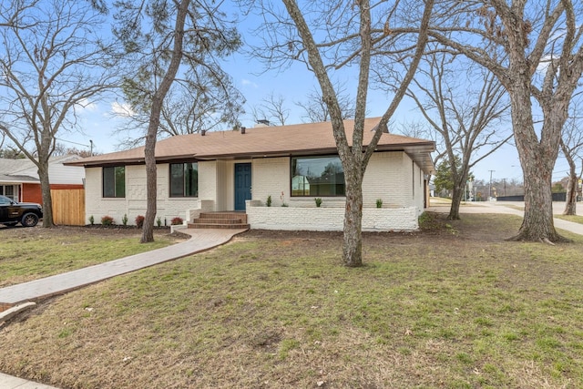 ranch-style home with brick siding and a front yard