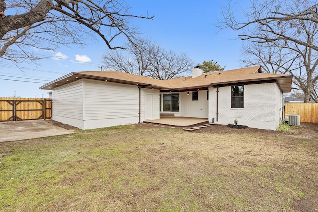 back of house with a lawn, a patio, and central AC