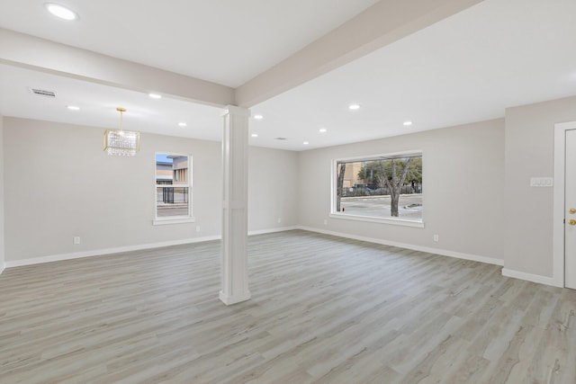 unfurnished living room with decorative columns and light hardwood / wood-style flooring