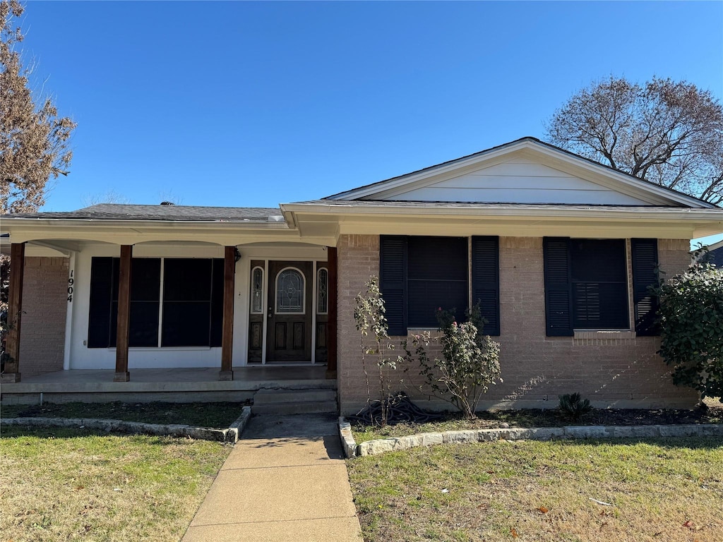 view of front of house with a front yard and a porch