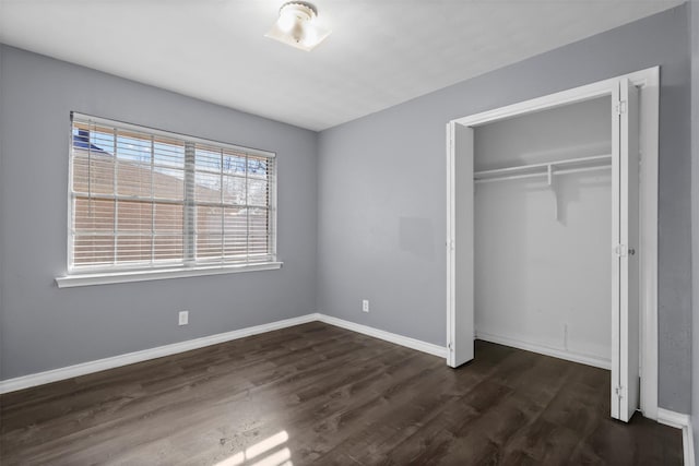 unfurnished bedroom with dark hardwood / wood-style flooring and a closet