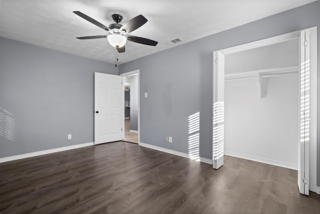 unfurnished bedroom with dark hardwood / wood-style flooring, a closet, and ceiling fan