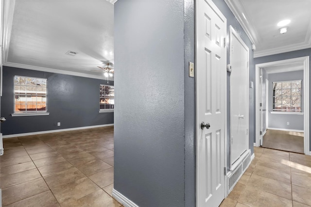 corridor featuring ornamental molding and light tile patterned floors