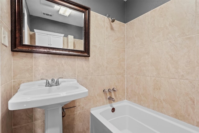 bathroom featuring tile walls and  shower combination