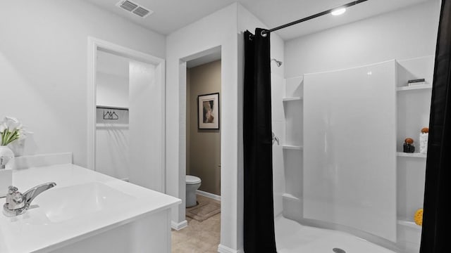 bathroom featuring vanity, toilet, and a shower