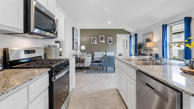 kitchen featuring sink, white cabinetry, lofted ceiling, and stainless steel appliances