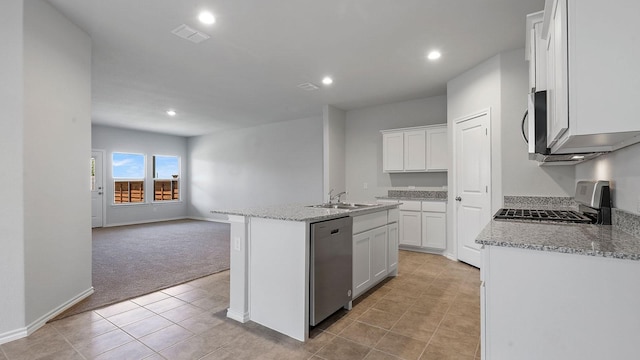 kitchen featuring light colored carpet, white cabinetry, a center island with sink, and stainless steel appliances