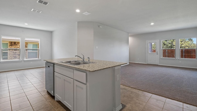 kitchen featuring light carpet, an island with sink, sink, light stone counters, and stainless steel dishwasher