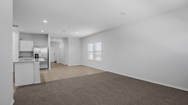 unfurnished living room featuring light carpet