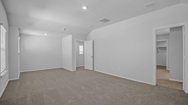 unfurnished room with vaulted ceiling and light colored carpet