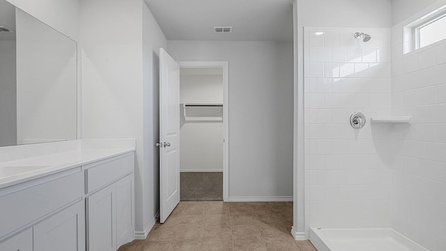 bathroom featuring a shower and vanity