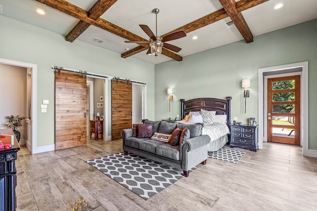 bedroom featuring ceiling fan, beamed ceiling, a barn door, and coffered ceiling