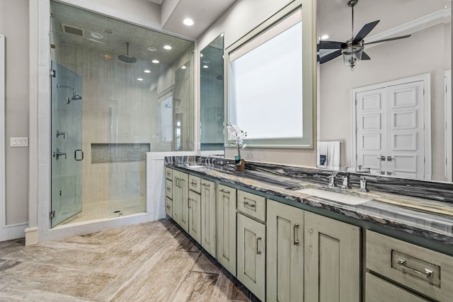 bathroom featuring a shower with shower door, ceiling fan, and vanity