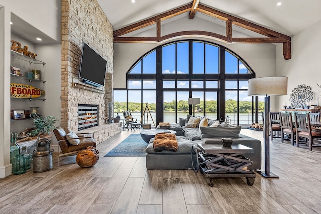 living room featuring high vaulted ceiling and a fireplace