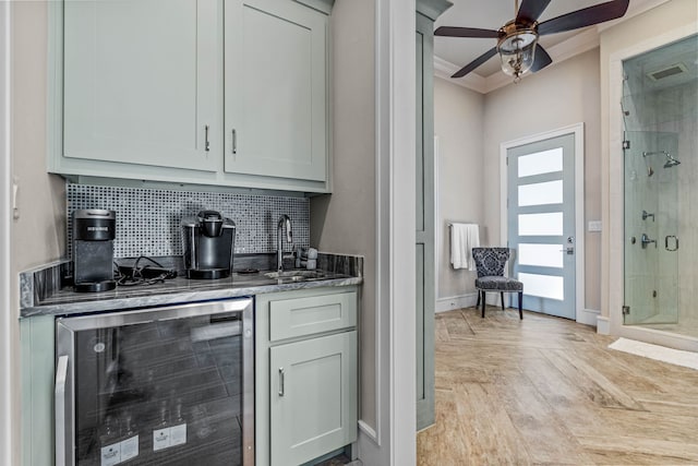 bar featuring ceiling fan, sink, backsplash, and wine cooler