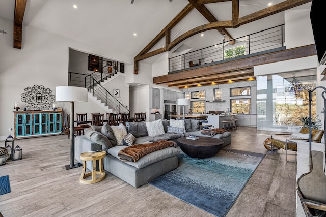 living room featuring beamed ceiling and a high ceiling