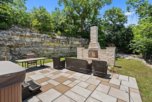 view of patio / terrace with an outdoor stone fireplace and area for grilling