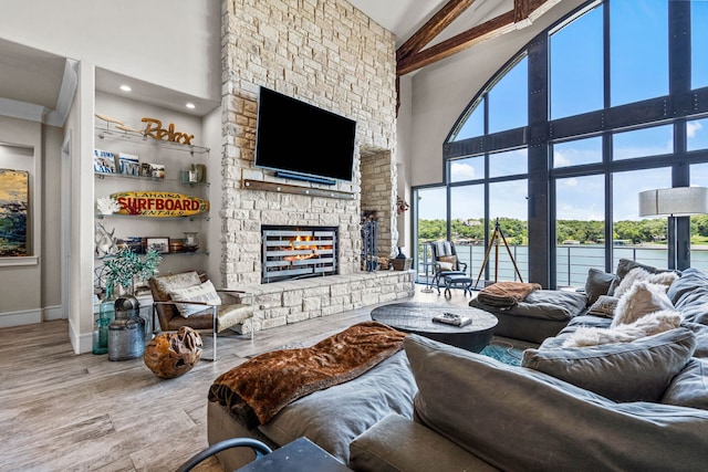 living room featuring high vaulted ceiling, beamed ceiling, a fireplace, and wood-type flooring