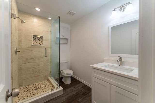 bathroom with vanity, walk in shower, hardwood / wood-style floors, and toilet