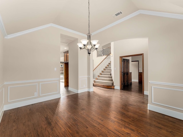 empty room featuring ornamental molding, dark hardwood / wood-style flooring, and vaulted ceiling