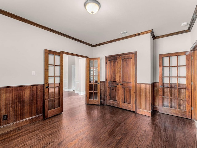 unfurnished room featuring french doors, ornamental molding, dark hardwood / wood-style flooring, and wood walls