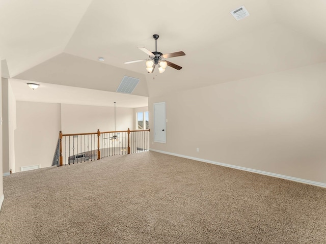 carpeted spare room featuring vaulted ceiling and ceiling fan