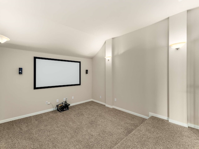 home theater room featuring lofted ceiling and carpet flooring