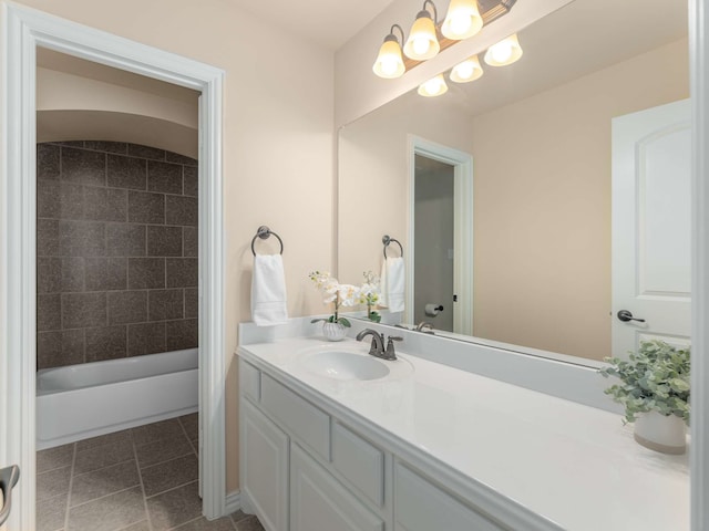 bathroom with an inviting chandelier, tile patterned floors, vanity, and tiled shower / bath