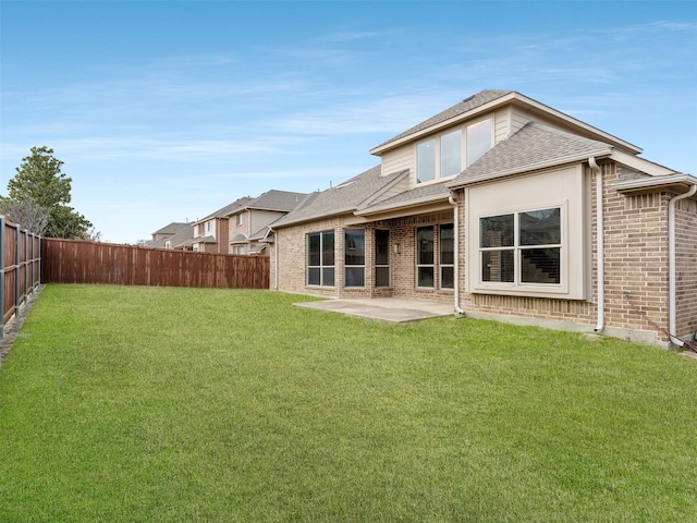 rear view of property featuring a lawn and a patio area