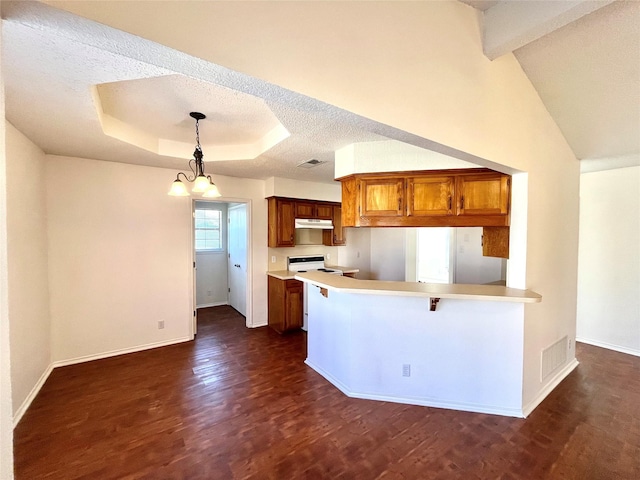 kitchen with white range with electric cooktop, hanging light fixtures, a raised ceiling, kitchen peninsula, and dark wood-type flooring